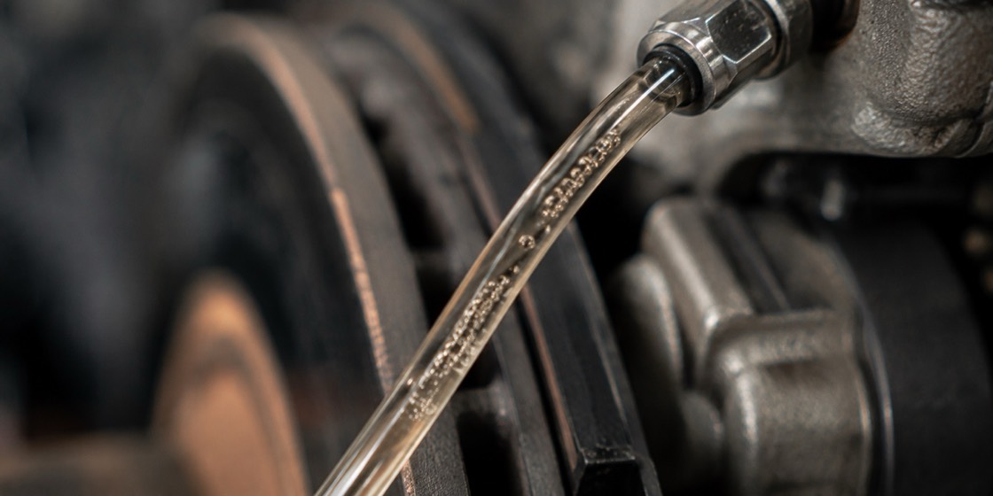 Air bubbles rising in a clear brake bleeder tube during a brake bleed